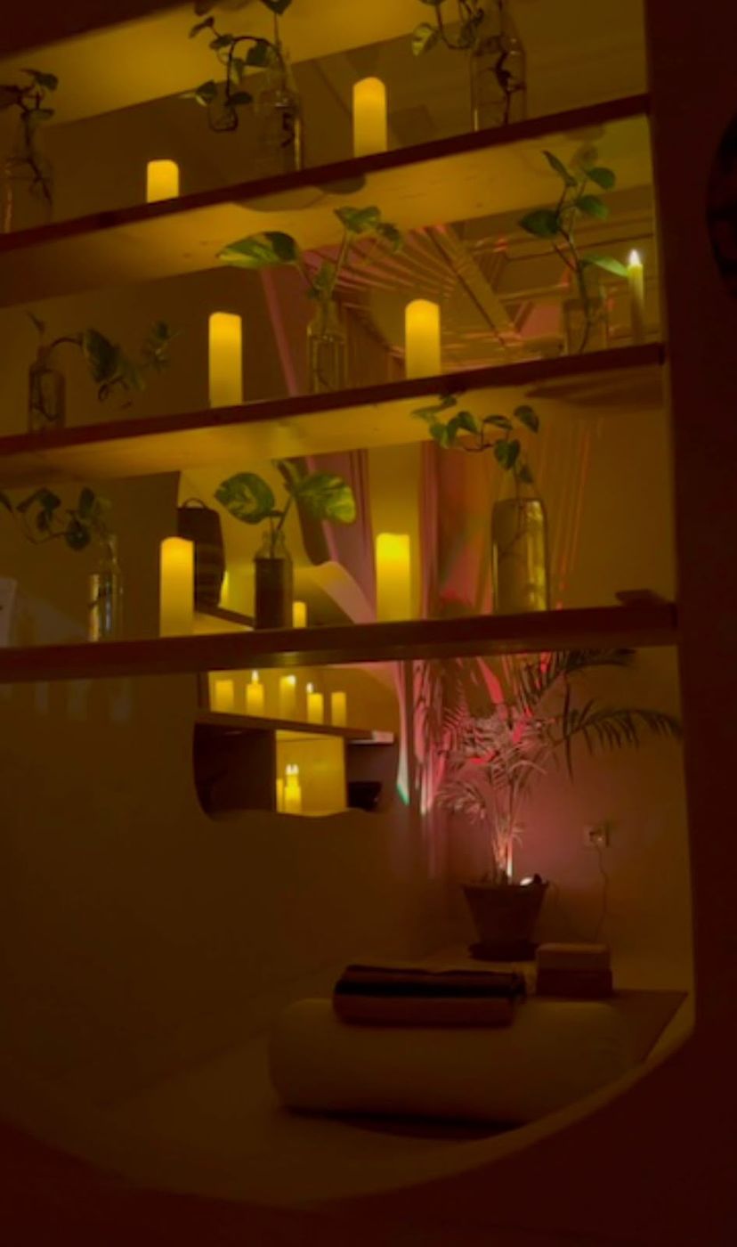 Candlelit shelves with trailing plants in the Yin room